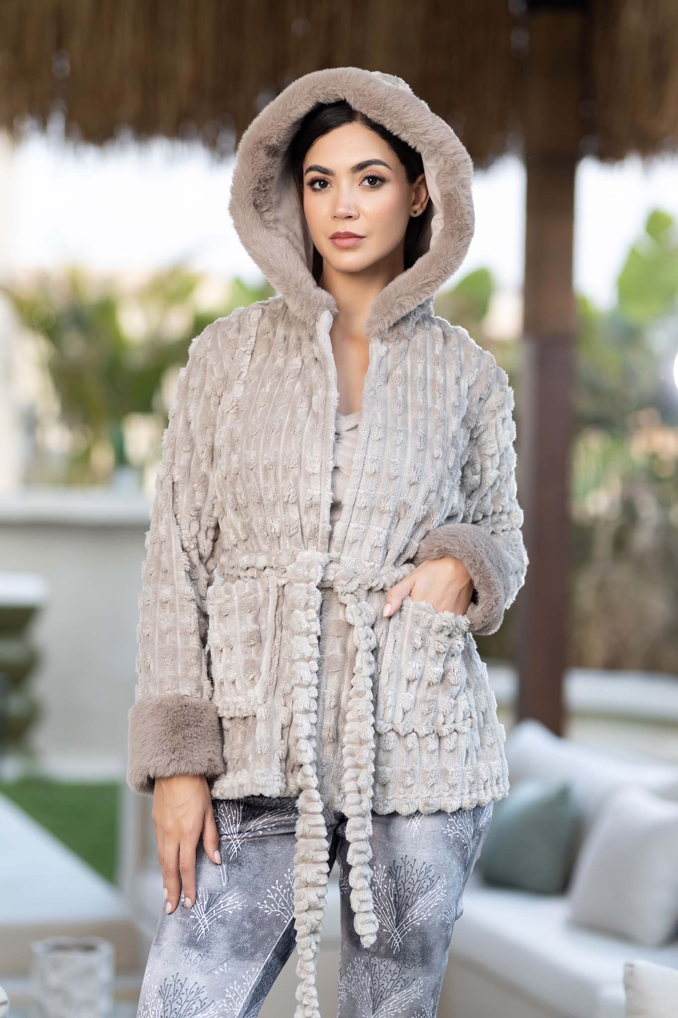 رداء رمادي منقوش بغطاء للرأس مع لمسات من الفرو وبنطلون بطبعة شجرة.